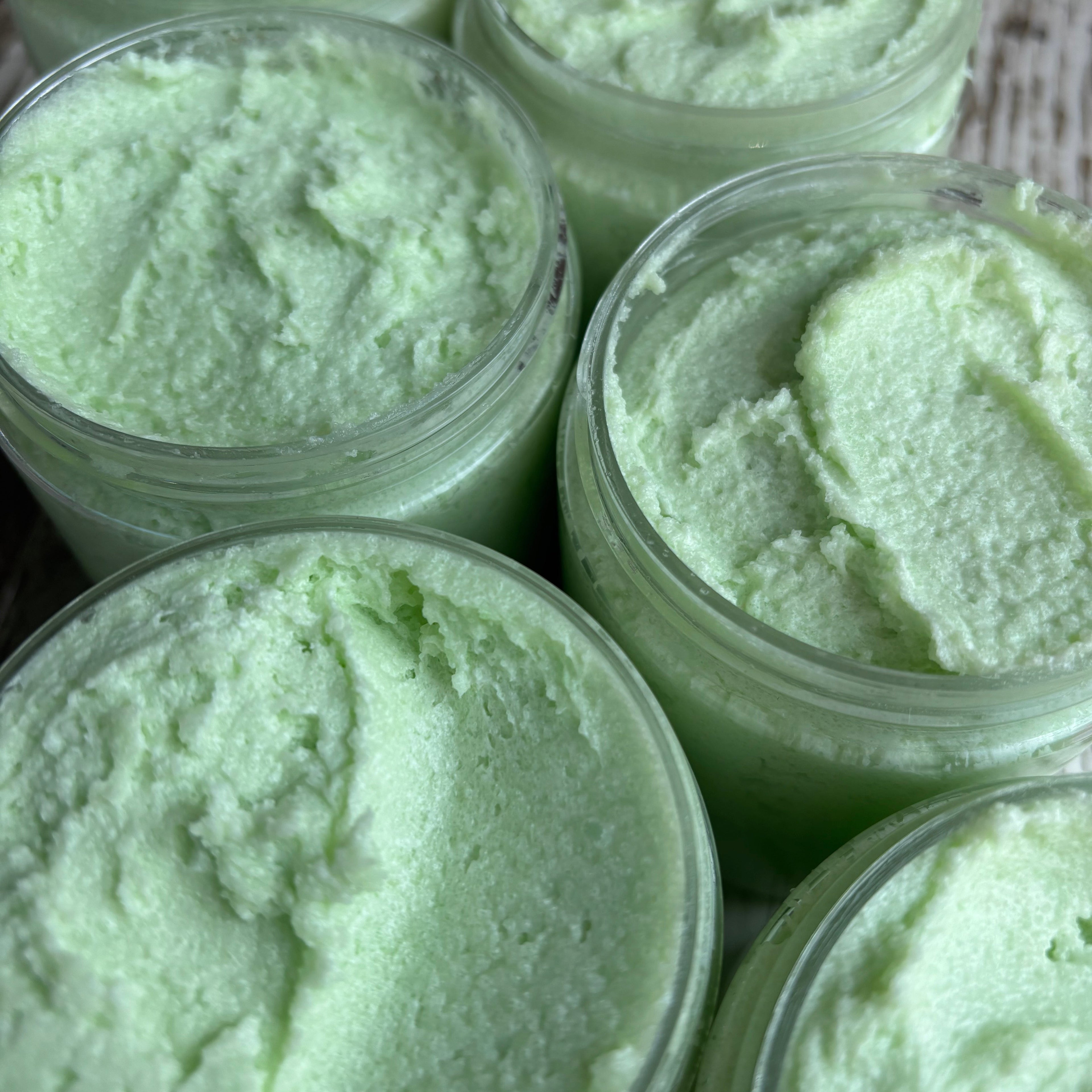 Jars of green sugar scrub with a textured surface.