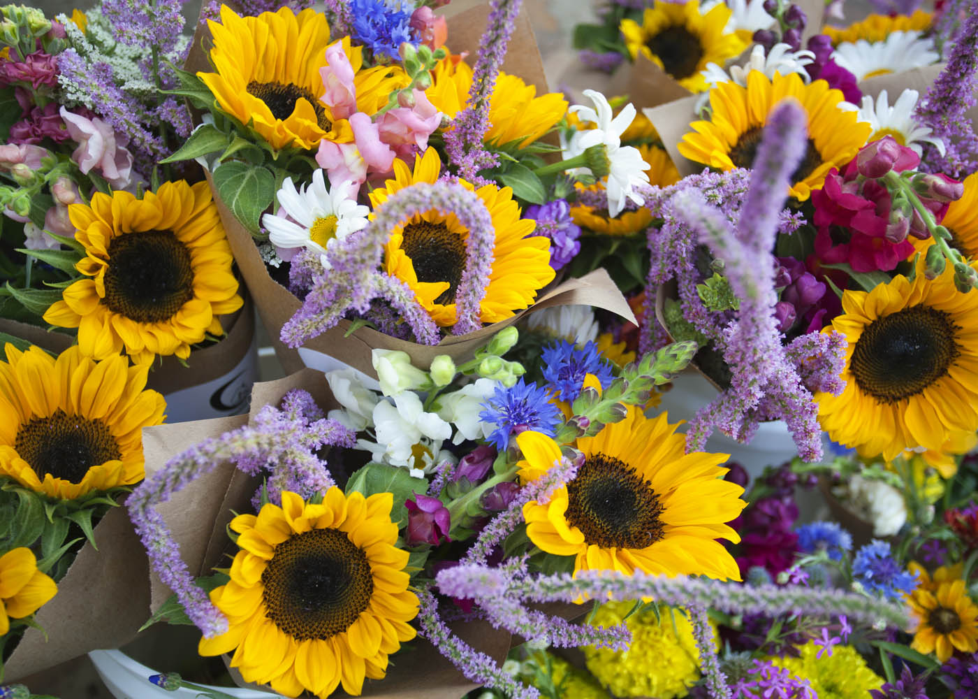Bouquets of sunflowers and other flowers with a focus on yellow and purple colors.