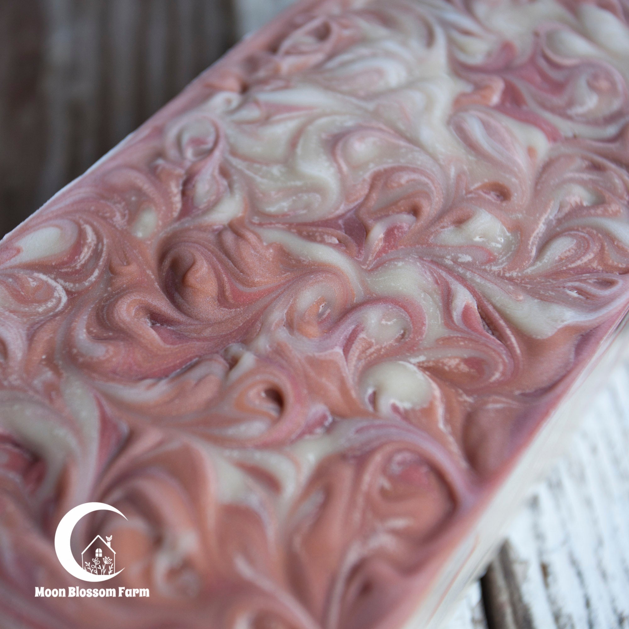 Swirled pink and white soap bar with 'Moon Blossom Farm' logo.