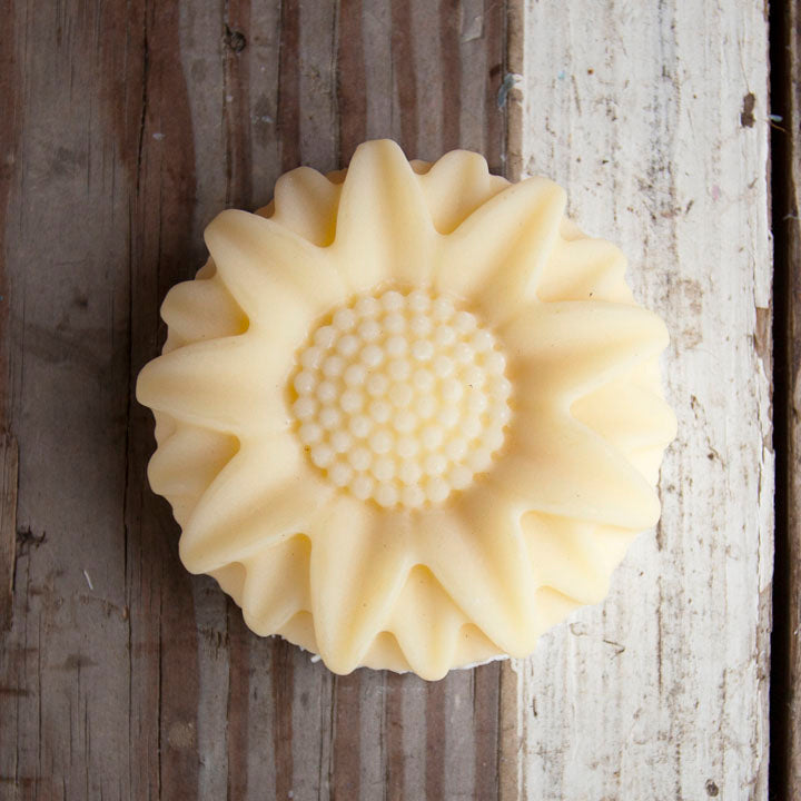 Sunflower-shaped soap on a rustic wooden surface