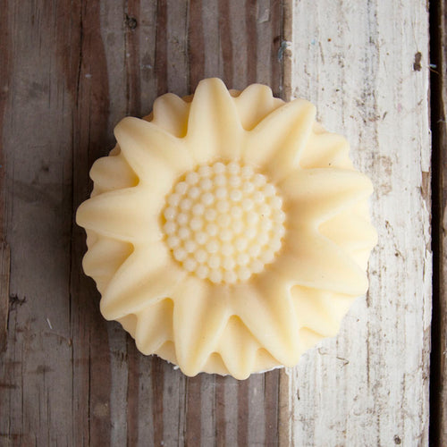 Sunflower-shaped soap on a rustic wooden surface
